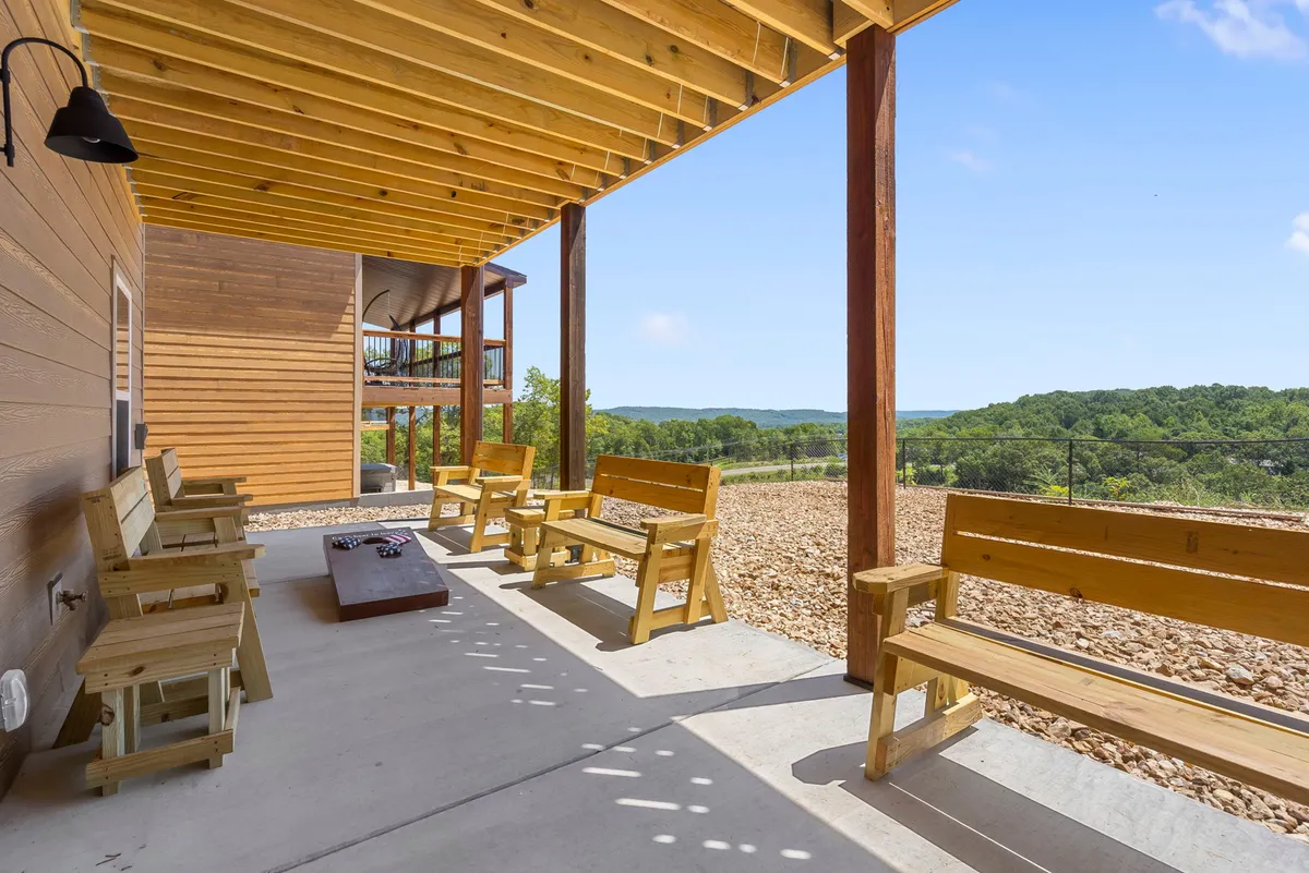 This image features a welcoming outdoor seating area with wooden benches arranged around a fire pit, offering a clear view of a serene landscape. The setting is relaxed and inviting, ideal for enjoying quiet mornings or evenings in the Ozarks' fresh air. The openness and natural surroundings visually suggest the kind of outdoor relaxation described in the section, and the setup is suitable for guests with pets who want to be outdoors together.