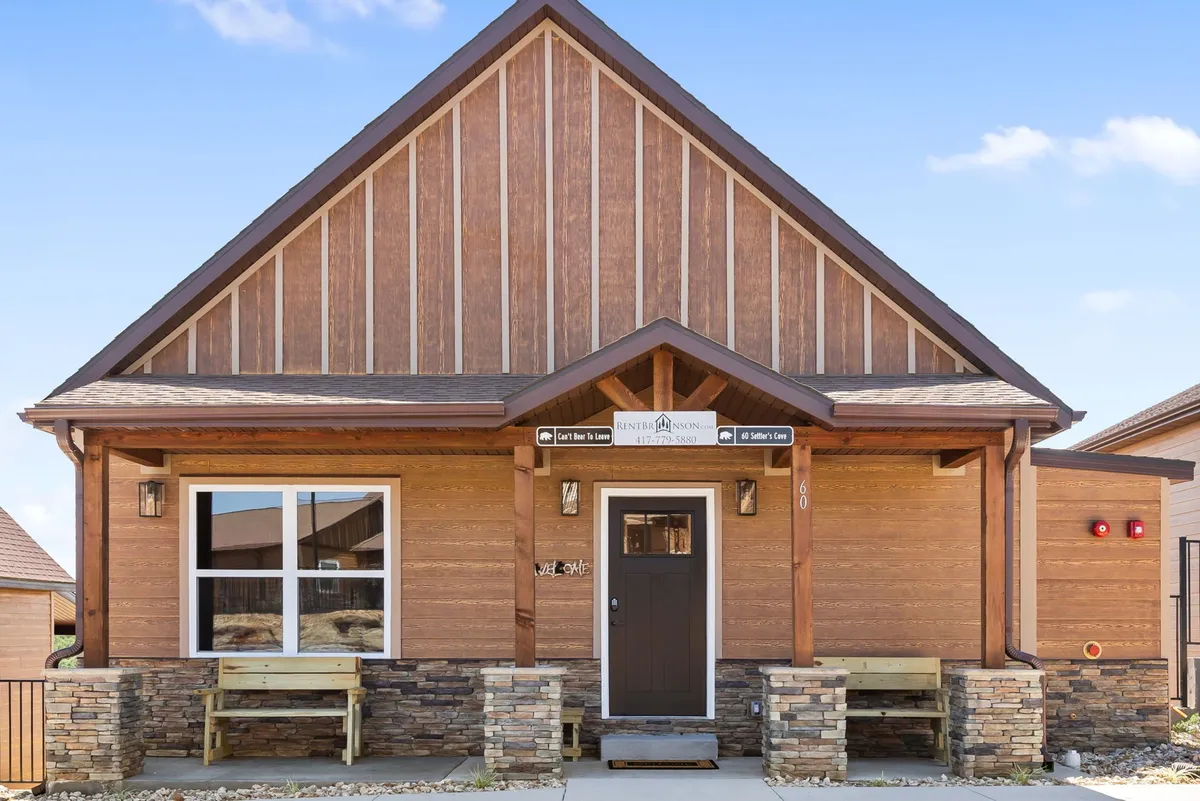 This image highlights the welcoming wooden façade of the property, featuring stone accents and a prominent front door. The inviting entrance, paired with sunset lighting, creates a sense of warmth and hospitality. This exterior shot suggests the start of a pet-friendly adventure and the lodge's embrace of all guests, including pets.